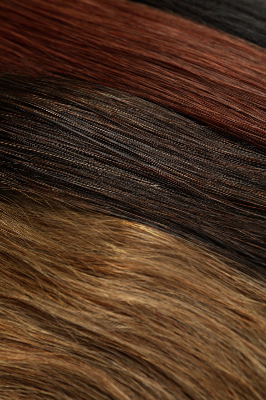 Different color female hair on whole background, close up